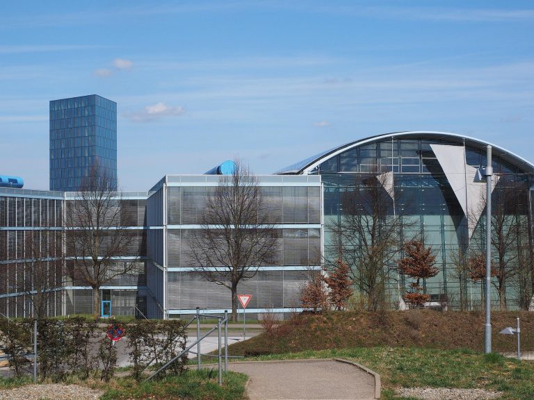 Grote witte opslagtent naast bedrijfsgebouw, flexibele opslagoplossing