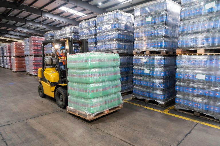 Verschillende typen pallets gestapeld in een magazijn voor opslag en transport van goederen
