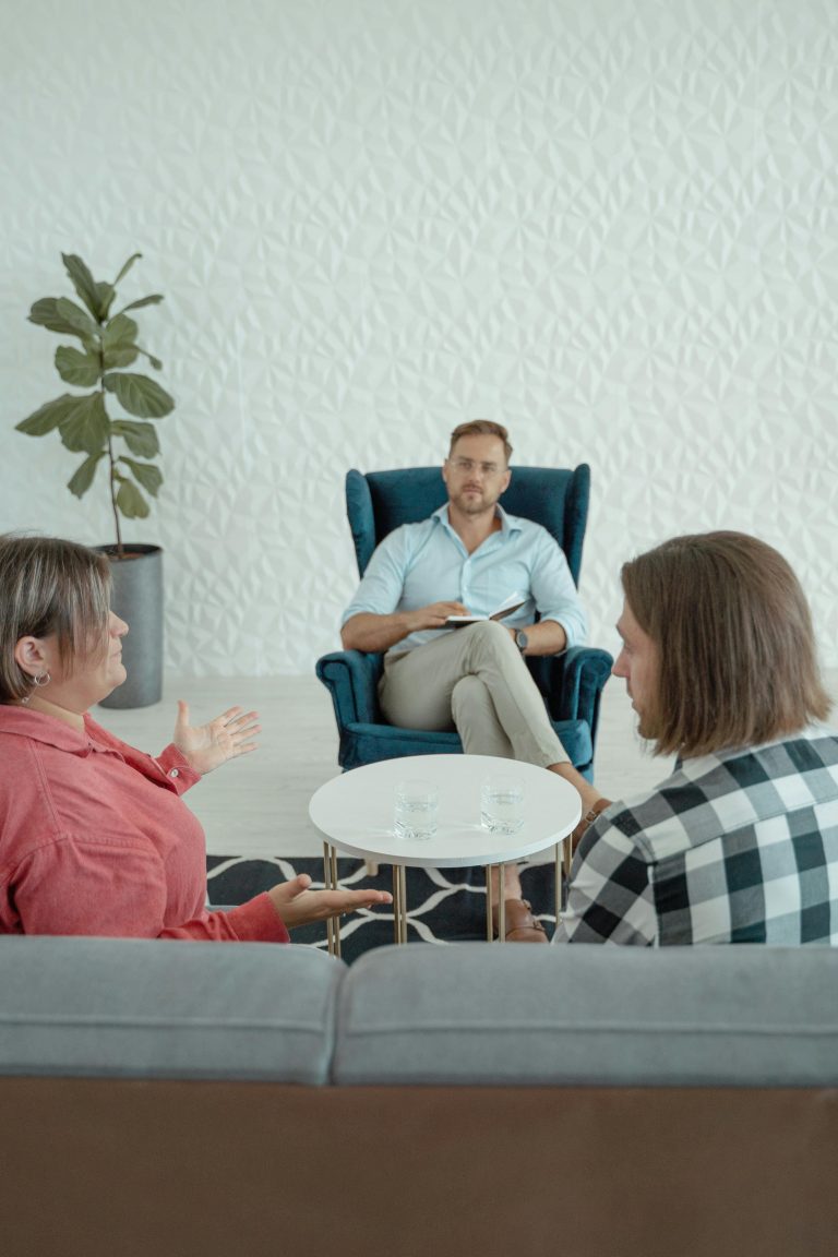 Mediation voor conflictoplossing: twee personen in gesprek met een neutrale bemiddelaar voor een constructieve dialoog