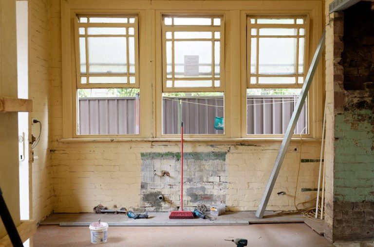 Hoe organiseer je een verbouwing: werker voert werkzaamheden uit in een renovatieproject met gereedschap en materialen